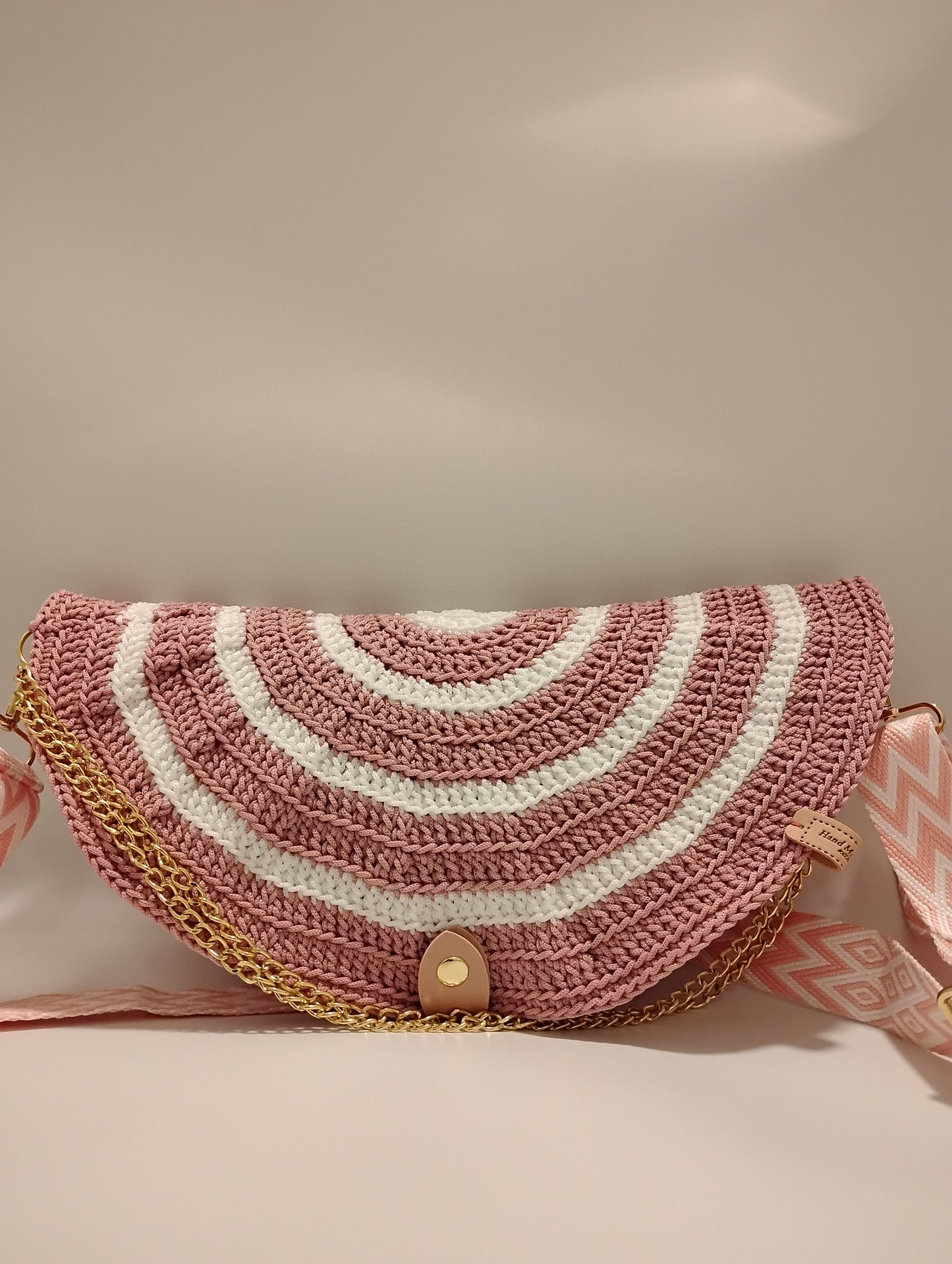 Mid Moon crossbody bag two-tone featuring a crochet pattern with pink and white stripes and gold chain detail.
