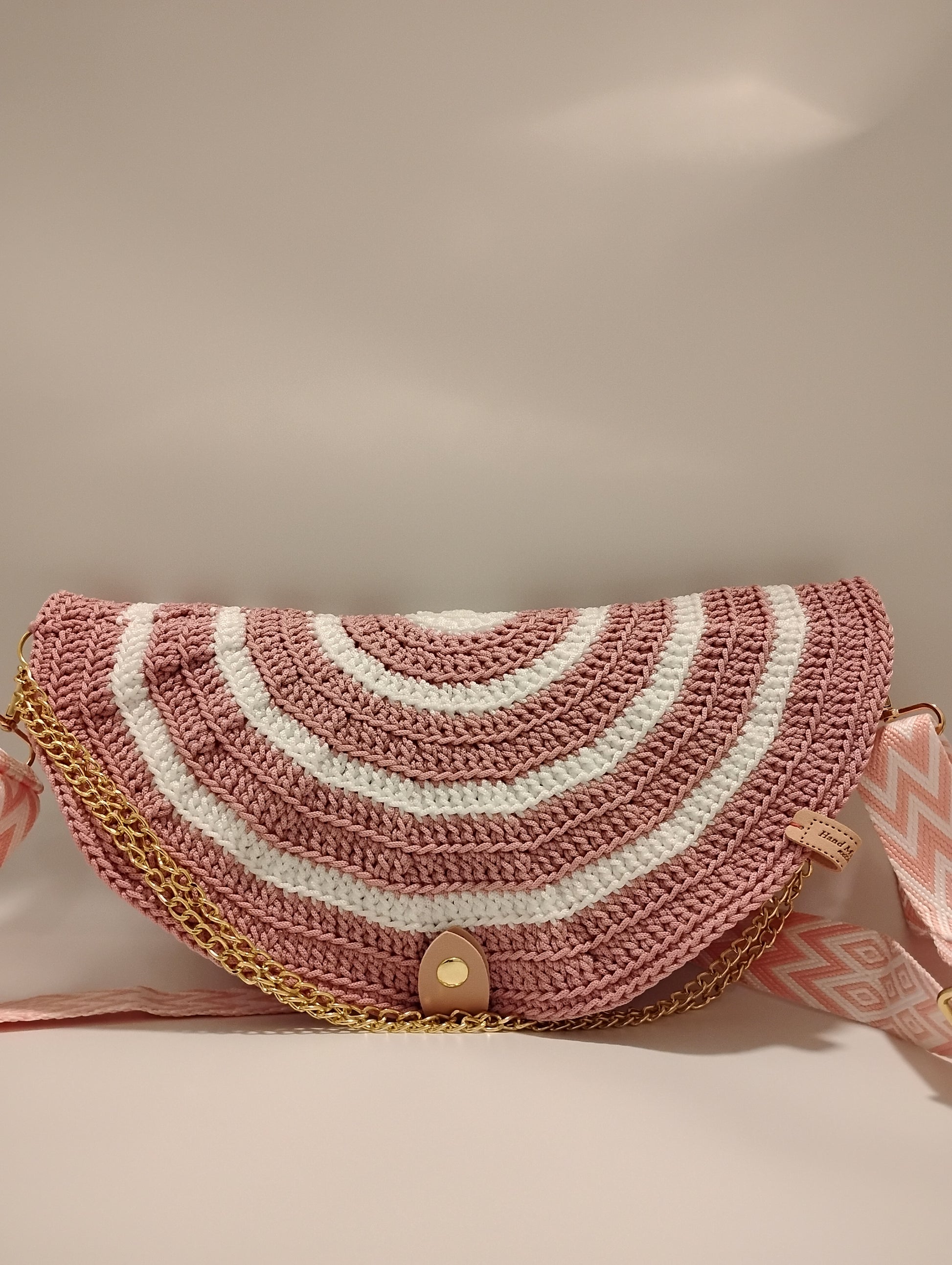 Mid Moon crossbody bag two-tone featuring a crochet pattern with pink and white stripes and gold chain detail.