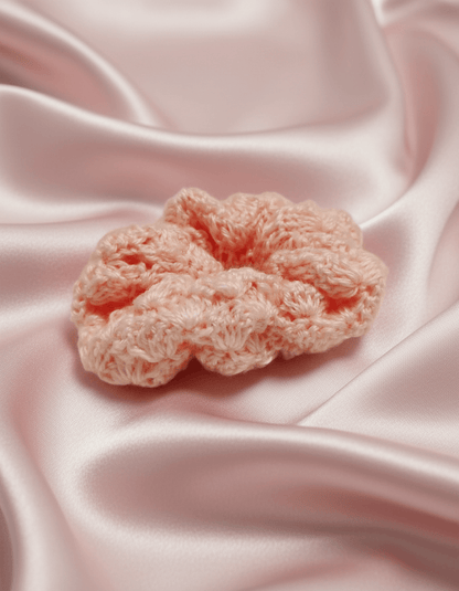 Hair ties soft handmade crochet accessory on satin fabric, highlighting its soft and light texture.